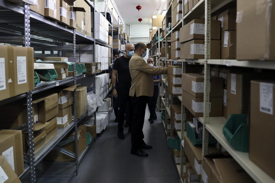 Caretaker Health Minister Hamad Hassan, front, inspects a medical warehouse in Beirut, Lebanon, Friday, June 11, 2021. Hassan raids warehouses in an effort to control those who are hoarding subsidized medical equipment and baby formula in order to sell them later at higher prices or on the black market. (AP Photo/Bilal Hussein)