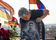 Irina Harutyunyan, mother of Movses Harutyunyan, who was killed during the fighting over Nagorno-Karabakh in 2020 year, mourns at his gave at the military cemetery outside Yerevan, Armenia, Monday, June 14, 2021. Hostilities flared in late September 2020, and the Azerbaijani military pushed deep into Nagorno-Karabakh and nearby areas in six weeks of fighting involving heavy artillery and drones that killed more than 6,000 people. (AP Photo/Mstyslav Chernov)