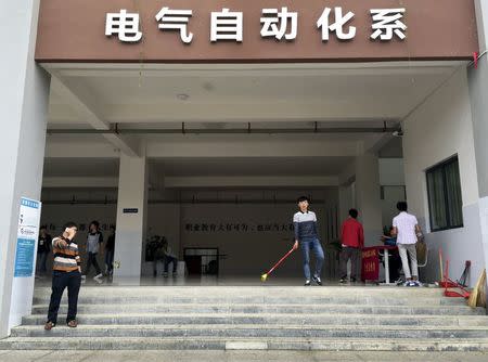 People stand at an entrance to a building inside the campus of the Guizhou Machinery Industry School, at Qingzhen Vocational Education City, in Guiyang, Guizhou province, China, September 24, 2015. REUTERS/Alexandra Harney