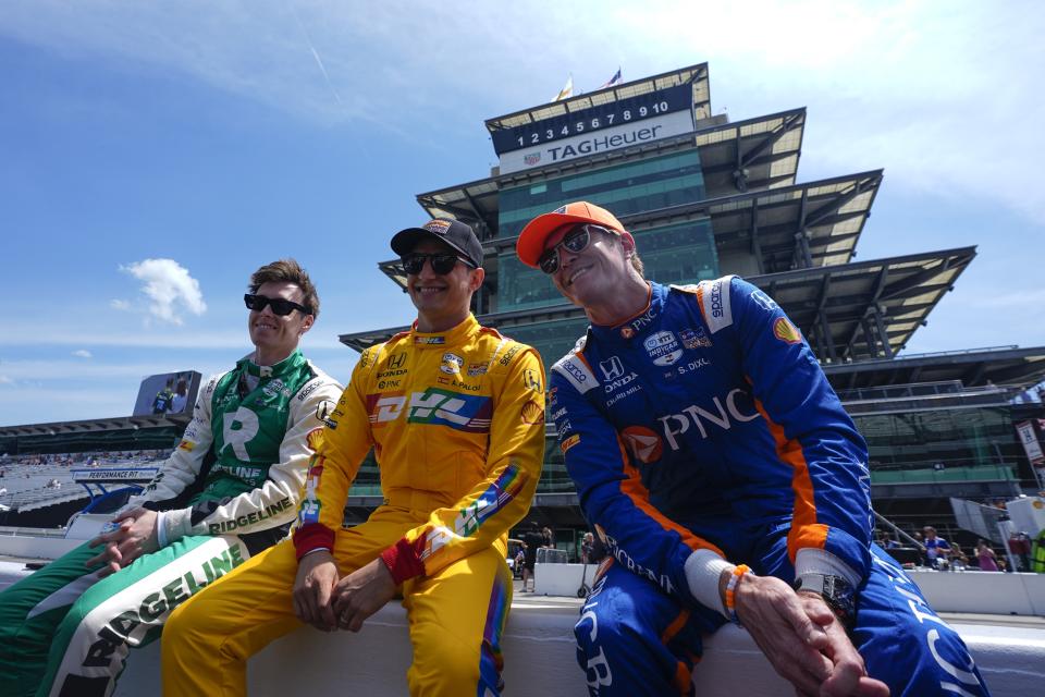 Marcus Armstrong, from left, of New Zealand, Alex Palou, of Spain, and Scott Dixon, of New Zealand, sit on a wall before a practice session for the Indianapolis 500 auto race at Indianapolis Motor Speedway, Monday, May 20, 2024, in Indianapolis. (AP Photo/Darron Cummings)