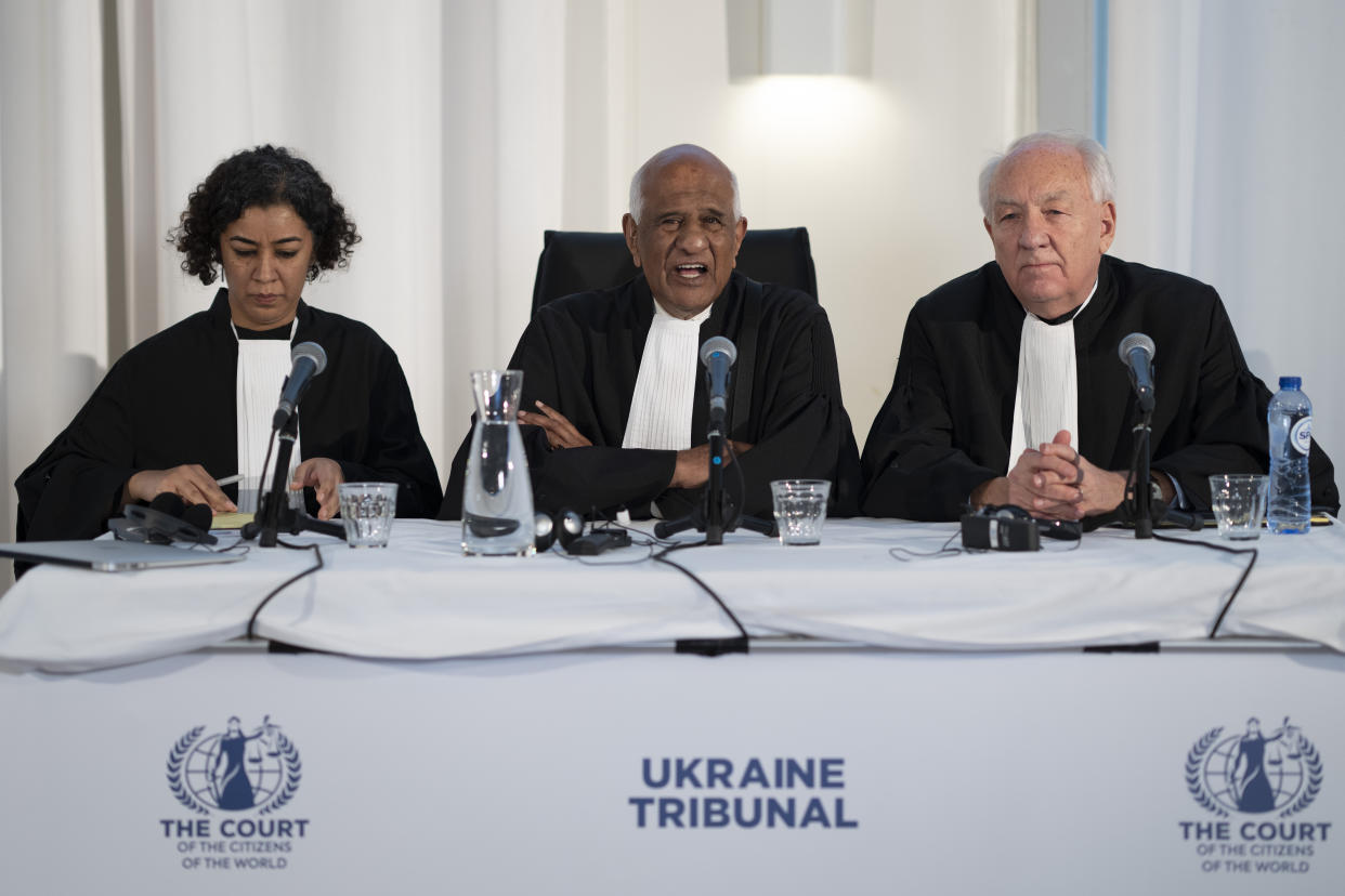 Judges Priya Pillai, left, Zak Yacoob, center, and Stephen Rapp, right open the 'people's tribunal' where prosecutors symbolically put Russian President Vladimir Putin on trial for the crime of aggression in Ukraine, in The Hague, Netherlands, Monday, Feb. 20, 2023. (AP Photo/Peter Dejong)