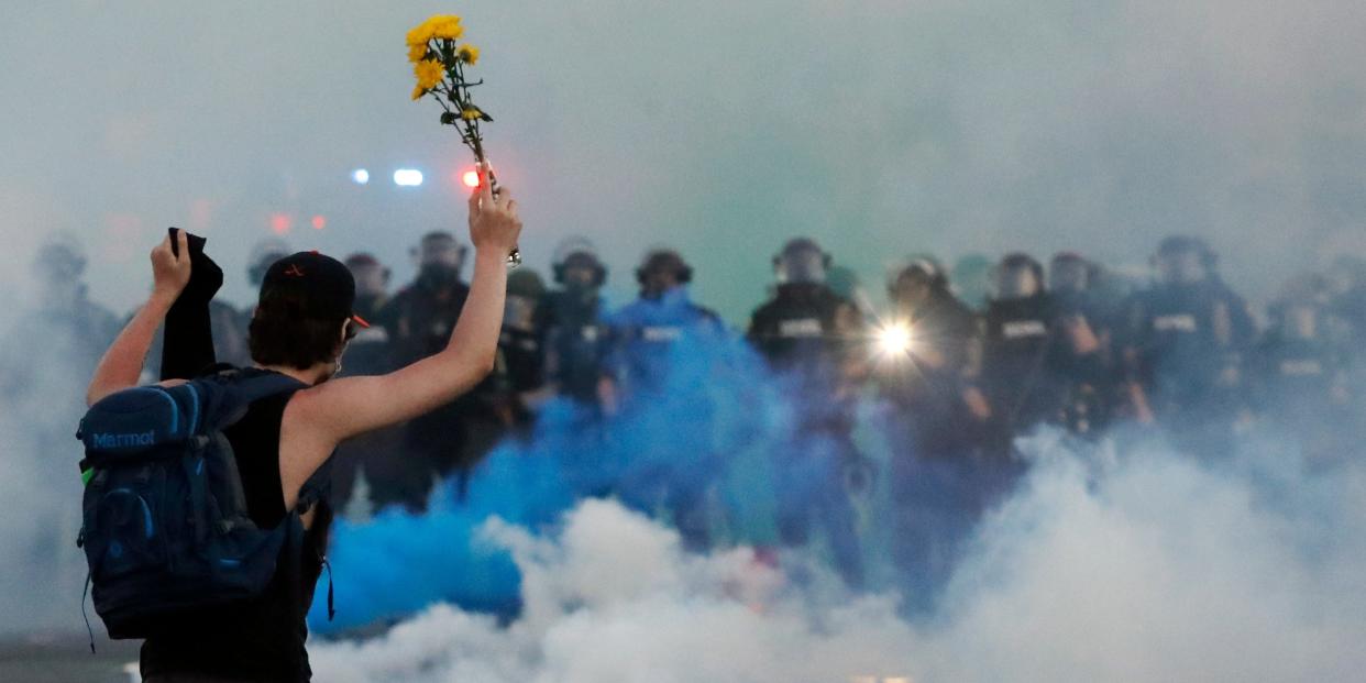 Police move towards a protester after curfew Saturday, May 30, 2020, in Minneapolis.