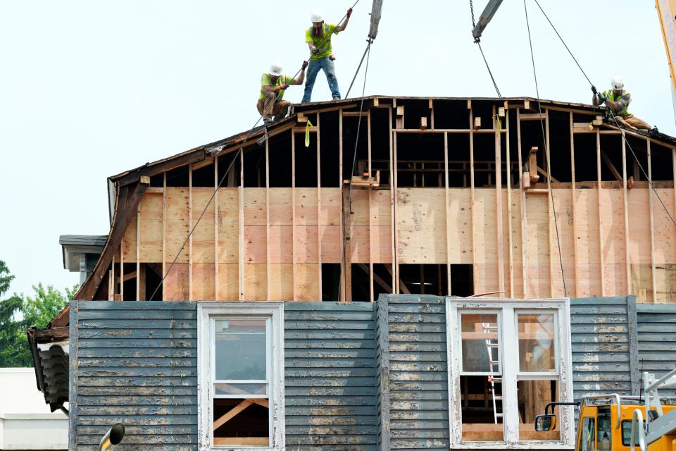 Men are shown on top of the Taylor Bliss historic home, in Englewood, after the tower was removed.  The home is being cut into multiple pieces and lifted off its foundation and moved to Eleanor Harvey Park, approximately 1.5 miles west of where it was originally built in 1876. Monday, June 26, 2023 