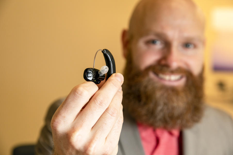 Sterling Sheffield, an assistant professor of Speech, Language, and Hearing Sciences at the University of Florida, holds an over-the-counter hearing aid Wednesday, Nov. 30, 2022, in Gainesville, Fla. OTC hearing aids started hitting the market in October afterthe FDA approved themfor adults with mild-to-moderate hearing loss, and Sheffield has been testing them. (AP Photo/Alan Youngblood)