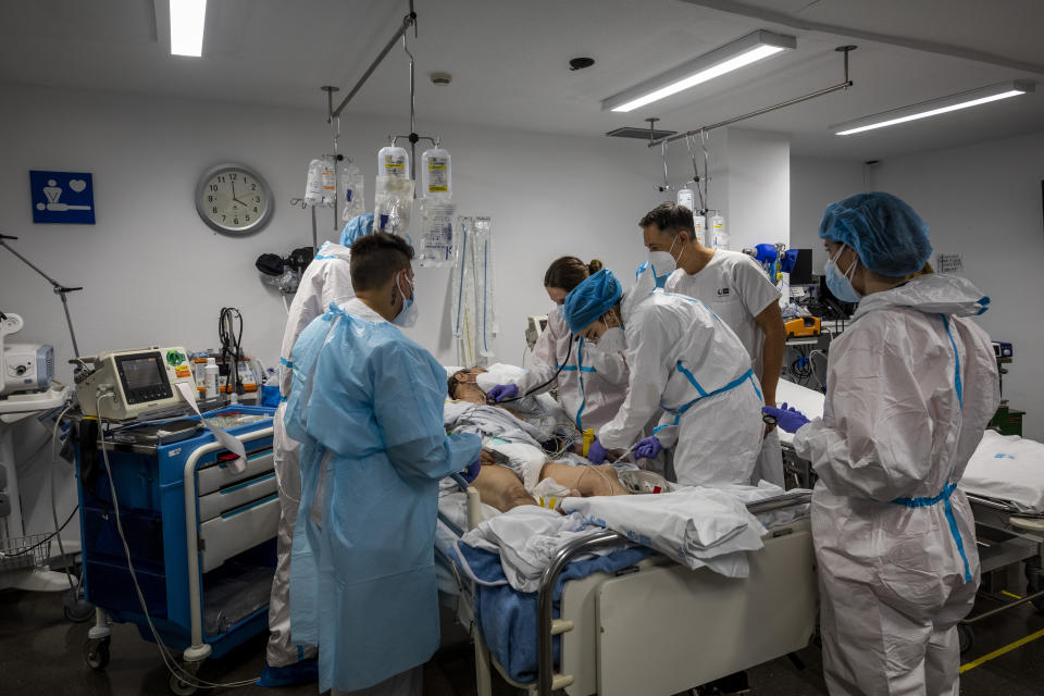 A medical team checks a COVID-19 patient at the emergency ward in the Severo Ochoa Hospital in Leganes, on the outskirts of Madrid, Spain, Wednesday, Feb. 17, 2021. One year ago, staff had to deal with the exasperation of fighting an unknown enemy, the fear of bringing the virus back home, the scarcity of protective gear and the bodies lined up in the morgue. At the height of contagion, the corridors of this facility of nearly 400 beds were crowded with patients on chairs and on stretches because there were no more beds for the steady flood of new patients. (AP Photo/Bernat Armangue)