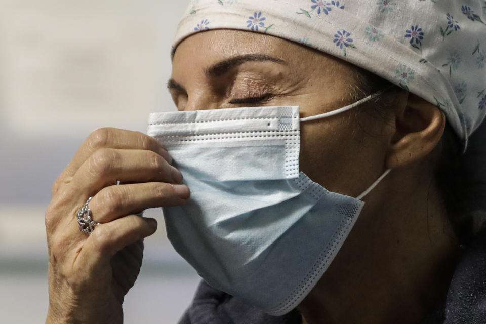 Nurse Cristina Settembrese gestures during an interview with the Associated Press outside the intensive care unit after finishing a night shift, at the San Paolo hospital, in Milan, Italy, Thursday, Oct. 15, 2020. (AP Photo/Luca Bruno)