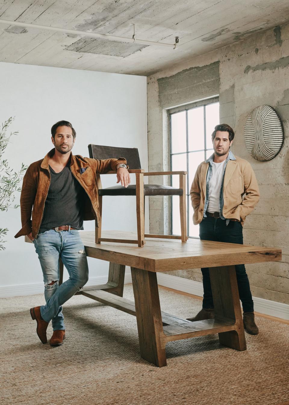Designers Harrison (left) and Nicholas Condos at their L.A. studio with the Davos oak dining table and Saddle dining chair.