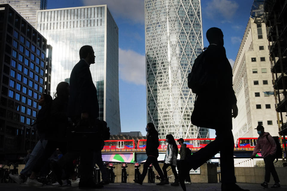 Office workers and commuters walk through Canary Wharf in London 