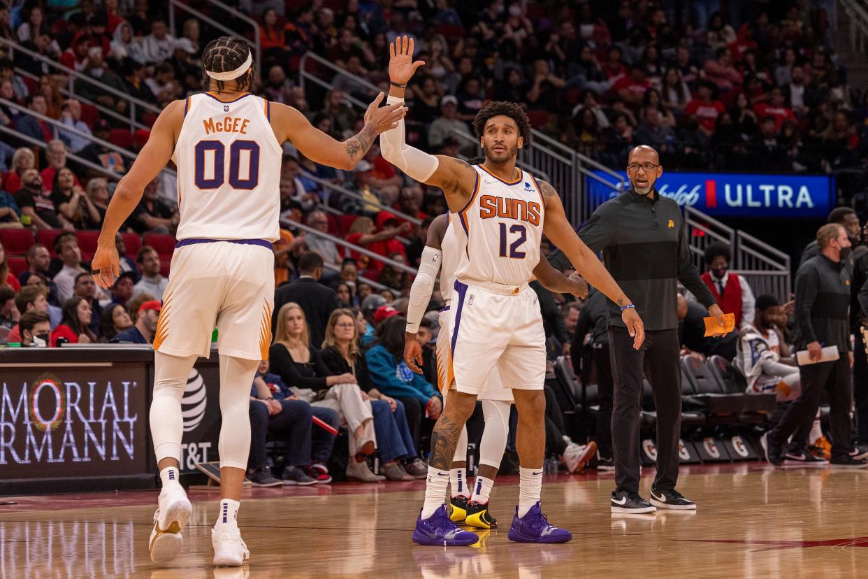 Mar 16, 2022; Houston, Texas, USA; Phoenix Suns forward Ish Wainright (12) celebrates with center JaVale McGee (00) before a Houston Rockets timeout in the second half at Toyota Center.