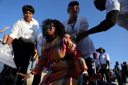 People respond to a woman as she reacts during a religious retreat lead by T.B. Joshua, a Nigerian evangelical preacher on Mount Precipice, Nazareth