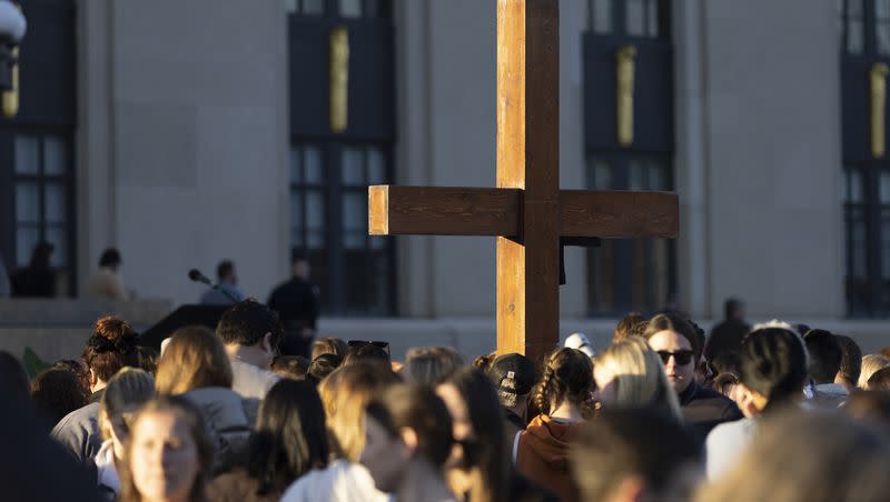 A cross stands above the crowd during a vigil held for victims of The Covenant School shooting on Wednesday, March 29, 2023, in Nashville, Tenn. 