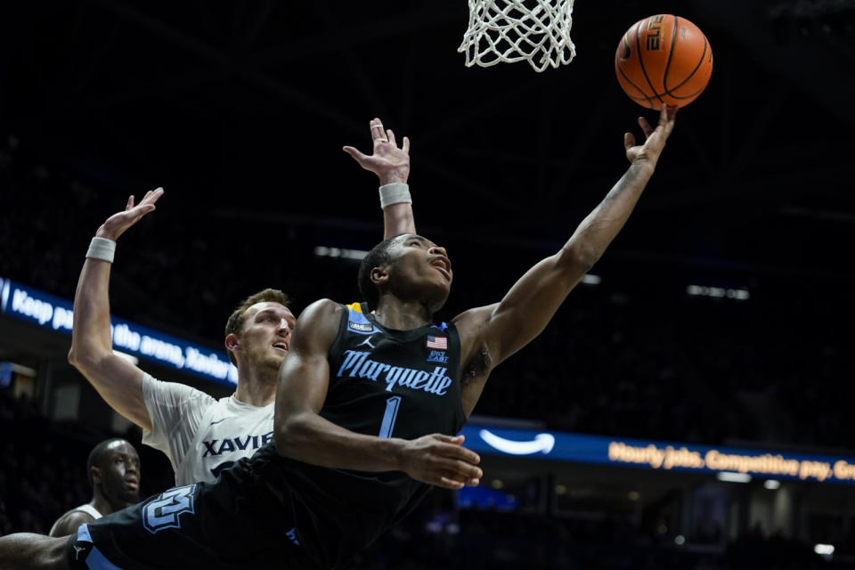 Marquette guard Kam Jones (1) shoots against Xavier's Jack Nunge during the second half of an NCAA college basketball game, Sunday, Jan. 15, 2023, in Cincinnati. (AP Photo/Jeff Dean)