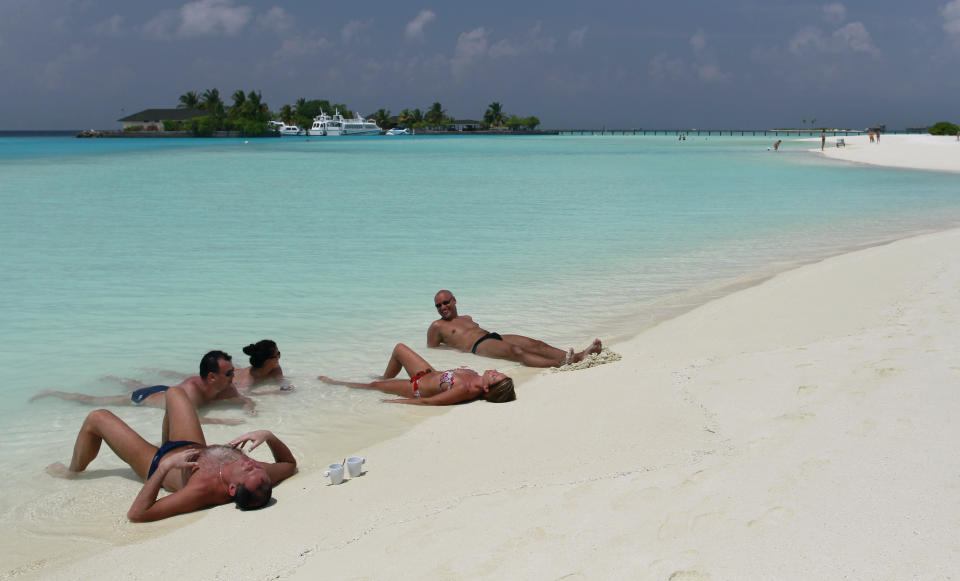 FILE- Tourists sunbathe in Paradise island resort in Male atoll, Maldives, Feb. 14, 2012.Relationship between India and the Maldives is facing challenges after officials in the tiny island nation made derogatory remarks against Prime Minister Narendra Modi’s posts that promoted the pristine beaches of India’s Lakshadweep archipelago. (AP Photo/ Gemunu Amarasinghe, File)