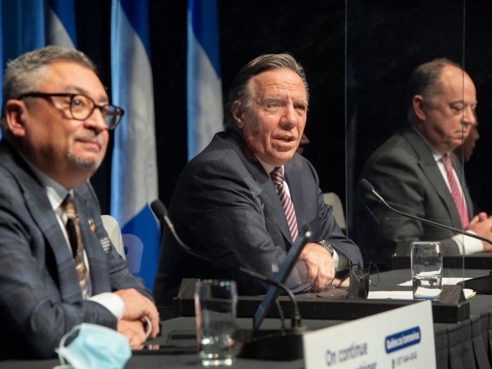 Quebec Premier François Legault, centre, says unvaccinated people should stay home because they are accounting for 50 per cent of hospitalizations.  (Graham Hughes/The Canadian Press - image credit)