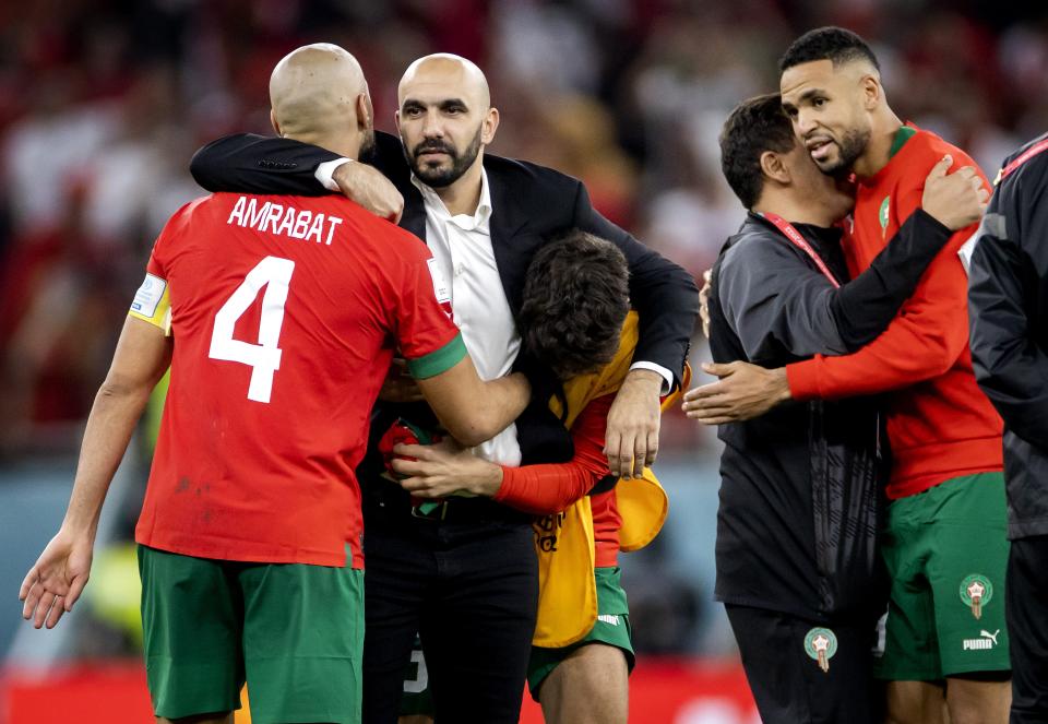 Morocco coach Walid Regragui (centre) congratulates his players after their 2022 World Cup quarter-final win over Portugal. 