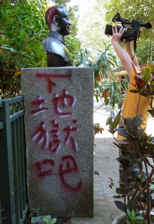 A man filming a statue of the late nationalist leader Chiang Kai-shek which has been vandalized with paint and reads "go to hell" in the northern city of Keelung