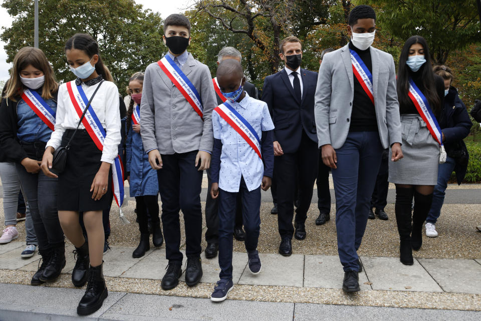 Young representatives of the municipal council attend ceremony with French President Emmanuel Macron in Les Mureaux, northwest of Paris, Friday, Oct. 2, 2020. President Emmanuel Macron, trying to rid France of what authorities say is a "parallel society" of radical Muslims thriving outside the values of the nation, is laying the groundwork Friday for a proposed law aimed at helping remedy the phenomenon. (Ludovic Marin / POOL via AP)