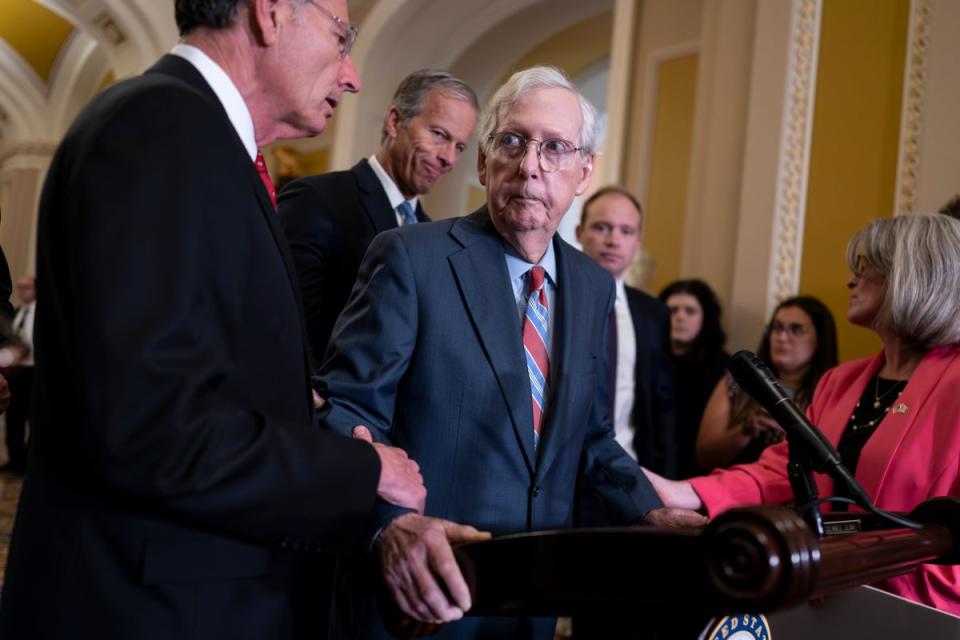 US Senate Minority Leader Mitch McConnell, center, is helped by, Senator John Barrasso and Senator Joni Ernst (Copyright 2023 The Associated Press. All rights reserved.)