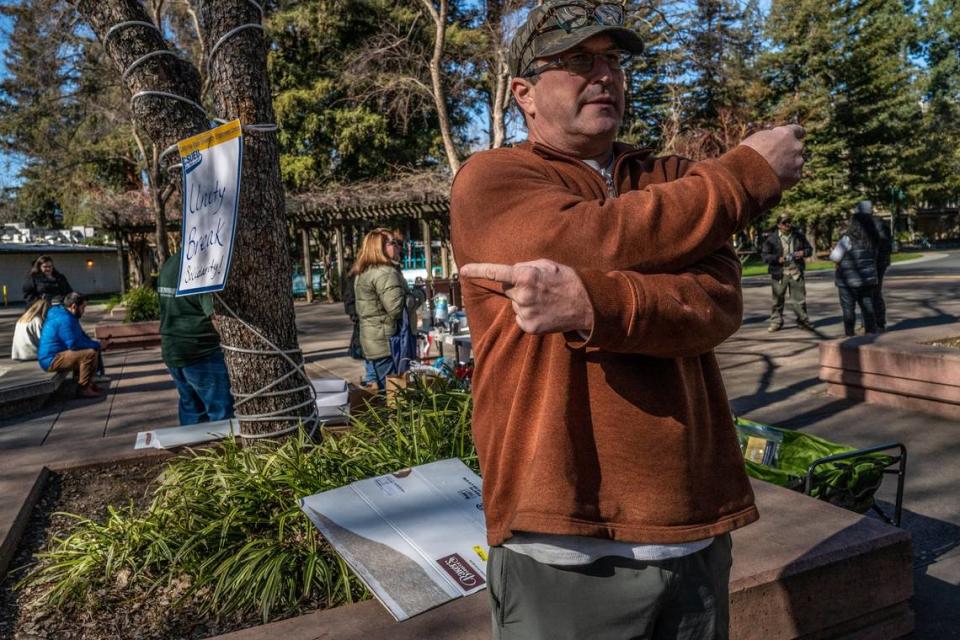 Terry Wilson, an officer of the California State University Employees Union, points in different directions at a union rally on Feb. 15, to describe efforts by state legislators and university officials to resolve the labor situation.