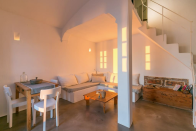 <p>The interior boasts the area’s signature pearl-white walls. The living room has high ceilings, a cozy dining area and a modern decor. (Airbnb) </p>