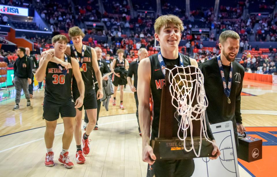 Metamora's Tyler Mason carries the Class 3A basketball state championship trophy off the court after the Redbirds defeated Chicago Simeon 46-42 for the title Saturday, March 11, 2023 at State Farm Center in Champaign.