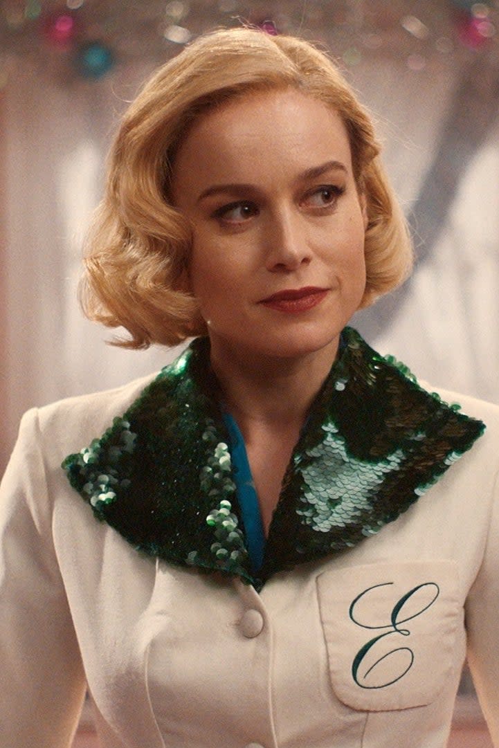 Brie Larson in a vintage kitchen wearing a white and green sequined outfit with the letter 