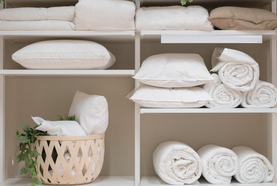 linen closet with pillows on shelves with towels clean laundry