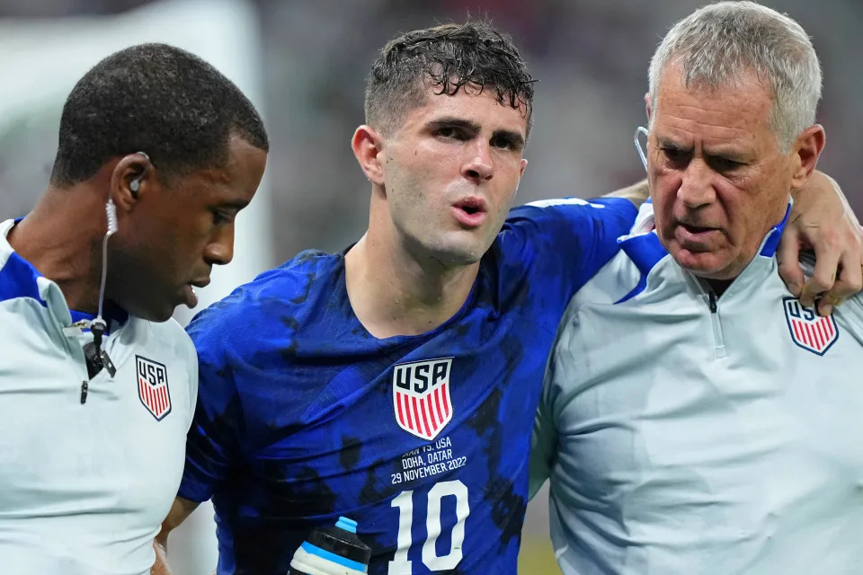 Nov 29, 2022; Doha, Qatar; United States of America forward Christian Pulisic (10) is helped after sustaining an injury after colliding with Iran goalkeeper Alireza Beiranvand (1) following his goal during the first half of a group stage during the 2022 World Cup at Al Thumama Stadium. Mandatory Credit: Danielle Parhizkaran-USA TODAY Sports