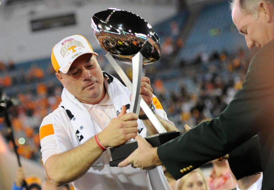 Tennessee head coach Butch Jones receives the TaxSlayer Bowl trophy after Tennessee's 45-28 victory over Iowa on Jan. 2, 2015 in Jacksonville, Fla.