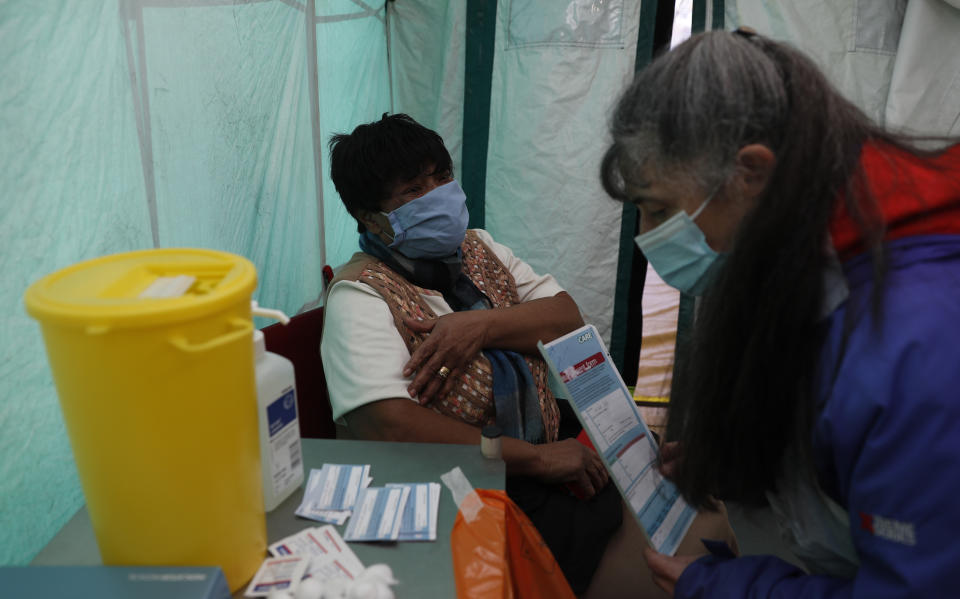 Dr Jacqueline Marshall talks to her patient Margaret Duncan Williams before giving her a dose of the AstraZeneca Covid-19 vaccine during the pilot project of pop up vaccination drive 'Vaxi Taxi' in Kilburn, London, Sunday, Feb. 28, 2021. The pilot scheme, funded by the Covid Crisis Rescue Foundation, aims to help ferry supplies and patients to temporary clinics set up in faith and community centres across the capital. People don’t even need to leave the backseat if they didn’t want to in order to receive their inoculation. (AP Photo/Alastair Grant)