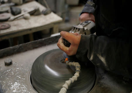 Factory worker Danny Bodie smoothes a curling stone in Kays Factory in Mauchline, Scotland, Britain, January 11, 2018. REUTERS/Russell Cheyne