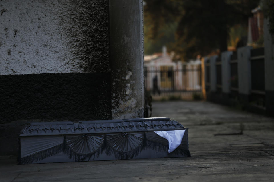 CORRECTS TO STATE THAT THE DECEASED DID NOT DIE OF COVID-19 AND THE CAUSE OF DEATH IS UNKNOWN - An empty coffin sits outside the crematorium at the San Nicolas Tolentino Pantheon as workers cremate bodies in the Iztapalapa area of Mexico City, Friday, May 22, 2020. Funeral parlors and crematoriums in Iztapalapa, a borough of 2 million people, say they have seen their work multiplied with the surging number of dead of COVID-19 in the capital's hardest-hit corner by the new coronavirus. (AP Photo/Marco Ugarte)