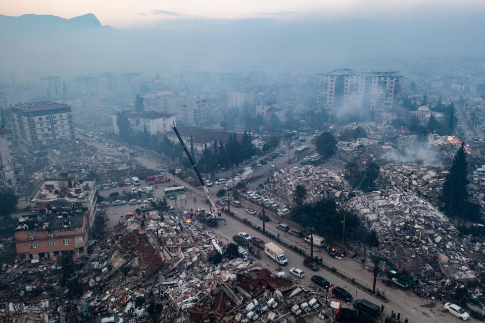 An aerial view shows smoke billowing from the scene of collapsed buildings on February 08, 2023 in Hatay, Turkey.