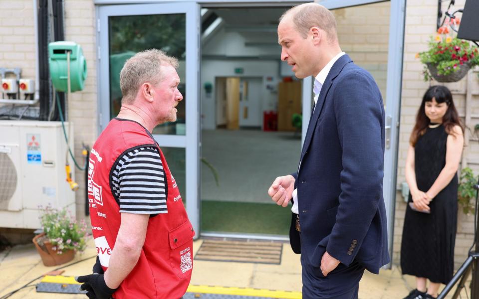 El Príncipe William, Príncipe de Gales, se reúne con un miembro durante su visita a Mosaic Clubhouse