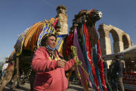 Wrestling camels, bearing elaborately decorated saddles, parade during a contest in Turkey's largest camel wrestling festival in the Aegean town of Selcuk, Turkey, Saturday, Jan. 15, 2022. Ahead of the games, on Saturday, camels were paraded in a beauty pageant titled "the most ornate camel contest" when they are decked out with colorful beaded muzzles, fabrics, pompoms, bells and Turkish flags. (AP Photo/Emrah Gurel)