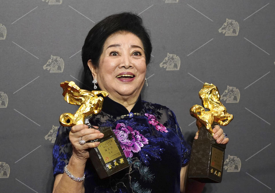 Taiwanese actress Chen Shu-fang holds her awards for Best Leading Actress and Best Supporting Actress at the 57th Golden Horse Awards in Taipei, Taiwan, Saturday, Nov. 21, 2020. Chen won for the film "Dear Tenant" at this year's Golden Horse Awards - one of the Chinese-language film industry's biggest annual events. (AP Photo/Billy Dai)