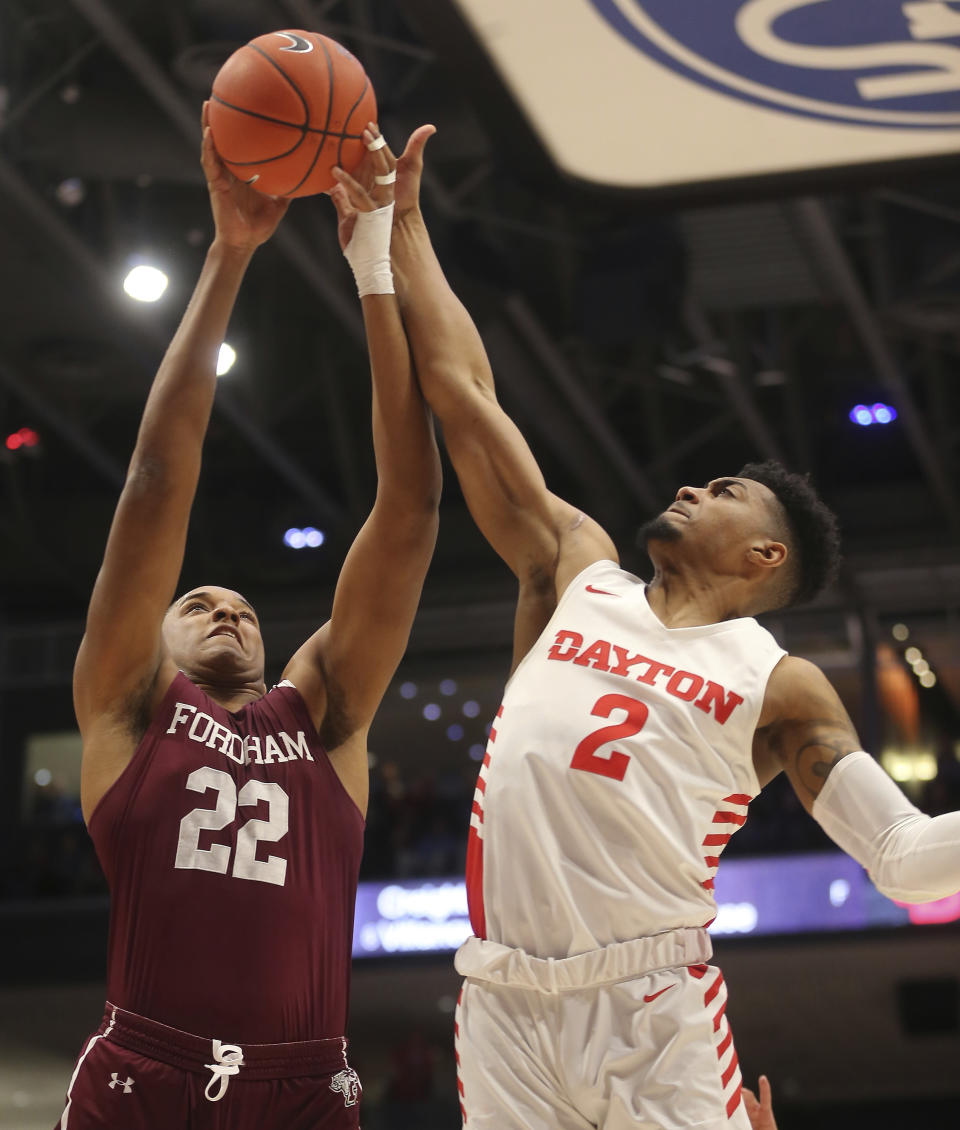 Fordham's Joel Soriano, left, battles Dayton's Ibi Watson (2) for a rebound during the first half of an NCAA college basketball game Saturday, Feb. 1, 2020, in Dayton , Ohio. (AP Photo/Tony Tribble)