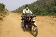 Yunusa Bawa, a community health worker, rides on a motorbike with a box of AstraZeneca coronavirus vaccines, in Sabon Kuje on the outskirts of Abuja, Nigeria, Monday, Dec 6, 2021. As Nigeria tries to meet an ambitious goal of fully vaccinating 55 million of its 206 million people in the next two months, health care workers in some parts of the country risk their lives to reach the rural population. (AP Photo/Gbemiga Olamikan)
