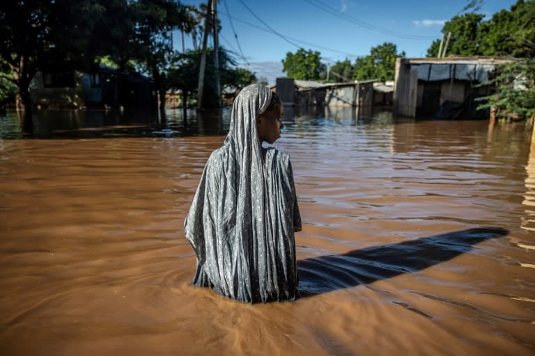 Une femme se fraie un chemin dans les eaux dans une zone inondée de Garissa, dans l'est du Kenya, le 9 mai 2024 (LUIS TATO)
