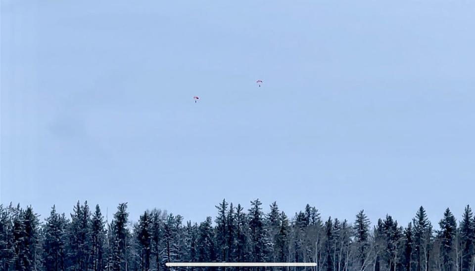 Two parachuters seen dropping from a Hercules aircraft over Fort Smith, N.W.T., as emergency crews respond to what the town is calling an "aviation incident."