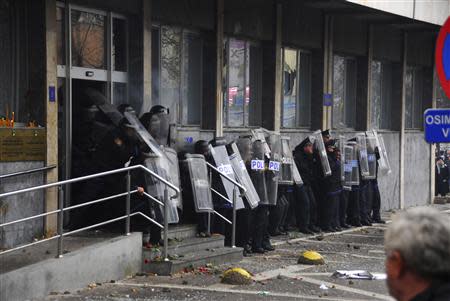 Police hold up their shields as they face anti-government protesters in Tuzla February 6, 2014. REUTERS/STRINGER