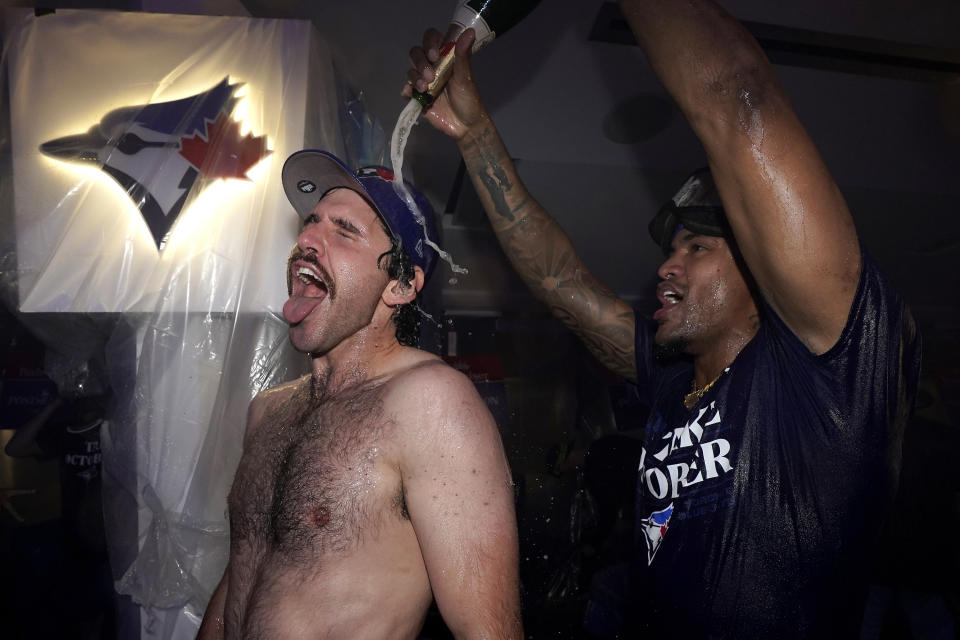 Toronto Blue Jays celebrate in the locker room after clinching a berth in the AL wild card series following a baseball game against the Tampa Bay Rays in Toronto, Sunday, Oct. 1, 2023. (Frank Gunn/The Canadian Press via AP)