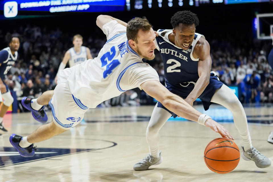 Xavier forward Jack Nunge (24) dives for the ball in front of Butler guard Eric Hunter Jr. (2) during the second half of an NCAA college basketball game, Saturday, March 4, 2023, in Cincinnati. (AP Photo/Joshua A. Bickel)