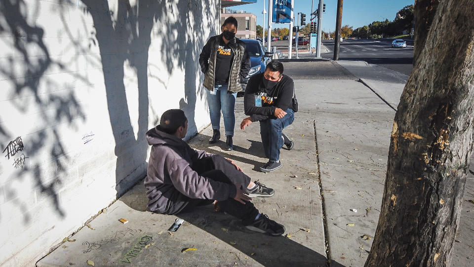 Two public safety behavioral health responders speak to a man on the street in Albuquerque, N.M. (NBC News)