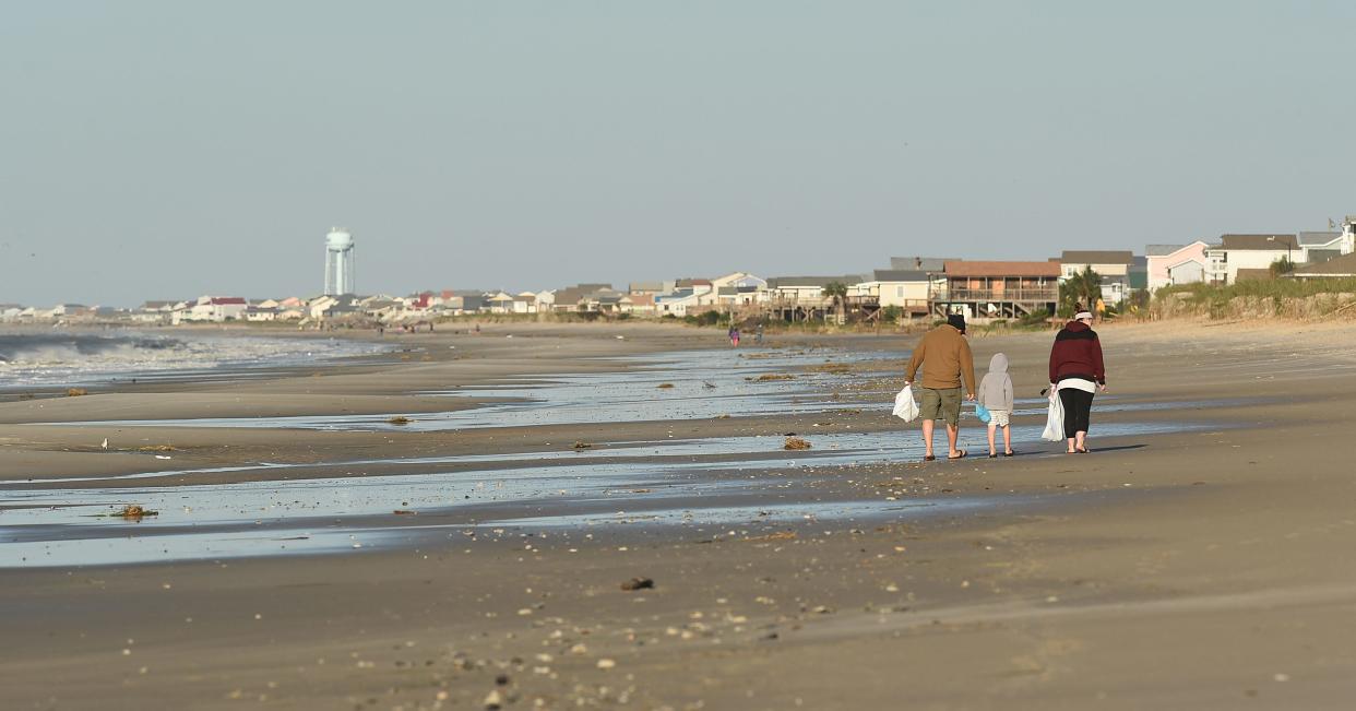 Shell hunters walk along the beach in Oak Island, N.C. after Hurricane Matthew moved through our area Saturday. Just after a storm passes is a great time to comb the beaches for shells.