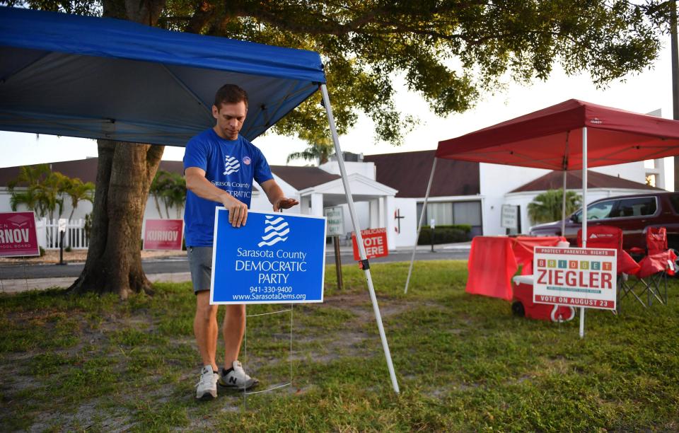 Daniel Kuether sets up a shade canopy and signs for Democratic Party volunteers outside the polling place at Trinity United Methodist Church in Sarasota on Primary Election Day, Aug. 23, 2022.