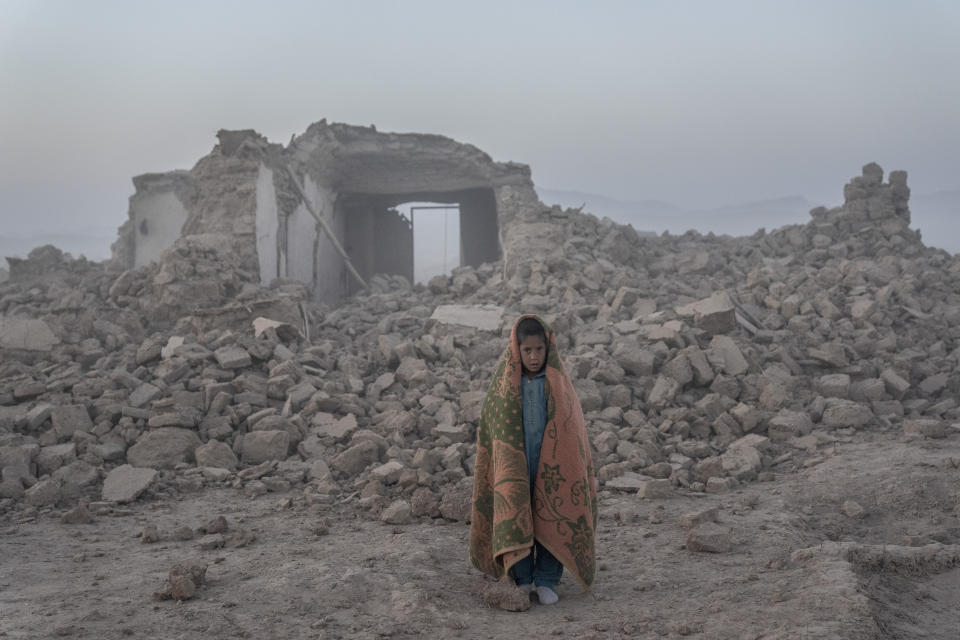 An Afghan boy stands in front of his house that was destroyed by the earthquake in Zenda Jan district in Herat province, western Afghanistan, Wednesday, Oct. 11, 2023. Another strong earthquake shook western Afghanistan on Wednesday morning after an earlier one killed more than 2,000 people and flattened whole villages in Herat province in what was one of the most destructive quakes in the country's recent history. (AP Photo/Ebrahim Noroozi)