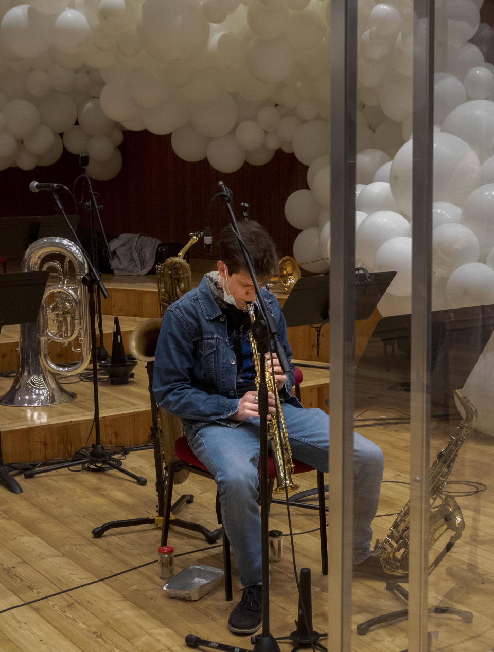 Giuseppe Verdi jazz orchestra musician plays his saxophone before playing a rehearsal at the Giuseppe Verdi Music Conservatory, in Milan, Italy, Friday, May 7, 2021. Whatever the instrument, flute, violin or drums, students at Italy's oldest and largest music conservatory have been playing behind plexiglass screens during much of the pandemic as the Conservatory found ways to preserve instruction throughout Italy’s many rolling lockdowns. (AP Photo/Antonio Calanni)