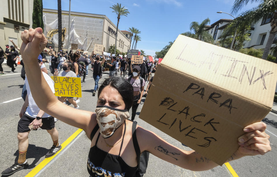 A woman holds a sign during a protest over the death of George Floyd in Los Angeles, Saturday, May 30, 2020. Protests across the country have escalated over the death of George Floyd who died after being restrained by Minneapolis police officers on Memorial Day, May 25. (AP Photo/Ringo H.W. Chiu)