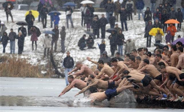 Men jump into a lake in an attempt to grab a wooden cross on Epiphany Day in Sofia, January 6, 2012. REUTERS/Hristo Rahnev